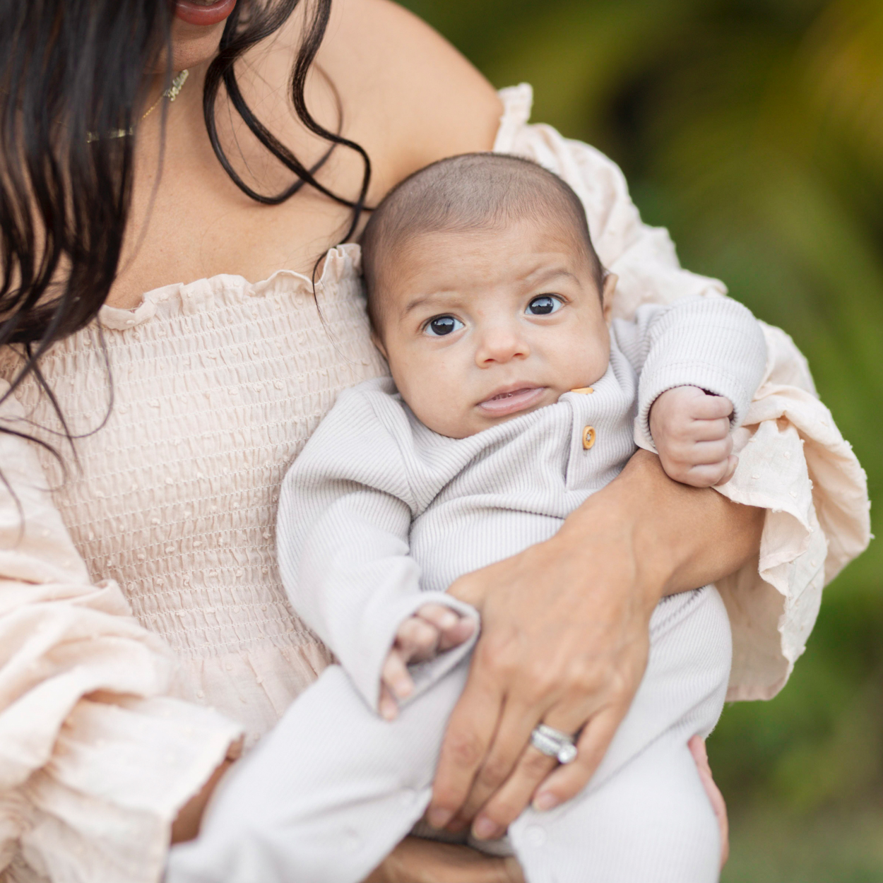 mom holding newborn outdoors